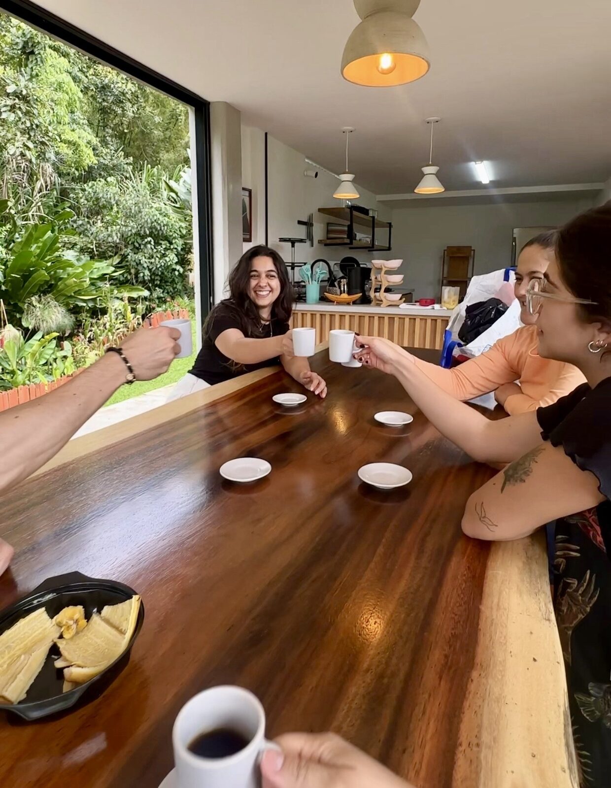 Brindis con café entre huéspedes de la casa — Isla de Pascua Hostel, Jardín